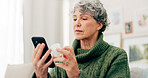 Senior woman, pills and information with cellphone in home on bottle for healthcare or diet. Package, reading and supplement with elderly female for vitamin with tech for pain with advice or help.