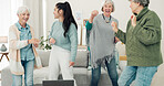 Dance, high five and senior women with a nurse in the living room of their retirement home together. Healthcare, wellness and fun with a group of people laughing while bonding together in a house