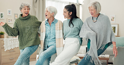 Dance, high five and senior women with a nurse in the living room of their retirement home together. Healthcare, wellness and fun with a group of people laughing while bonding together in a house