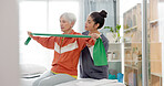 Senior woman doing a exercise with a resistance band for physiotherapy with a nurse in clinic. Fitness, healthcare and elderly female patient doing arm workout with therapist in rehabilitation center