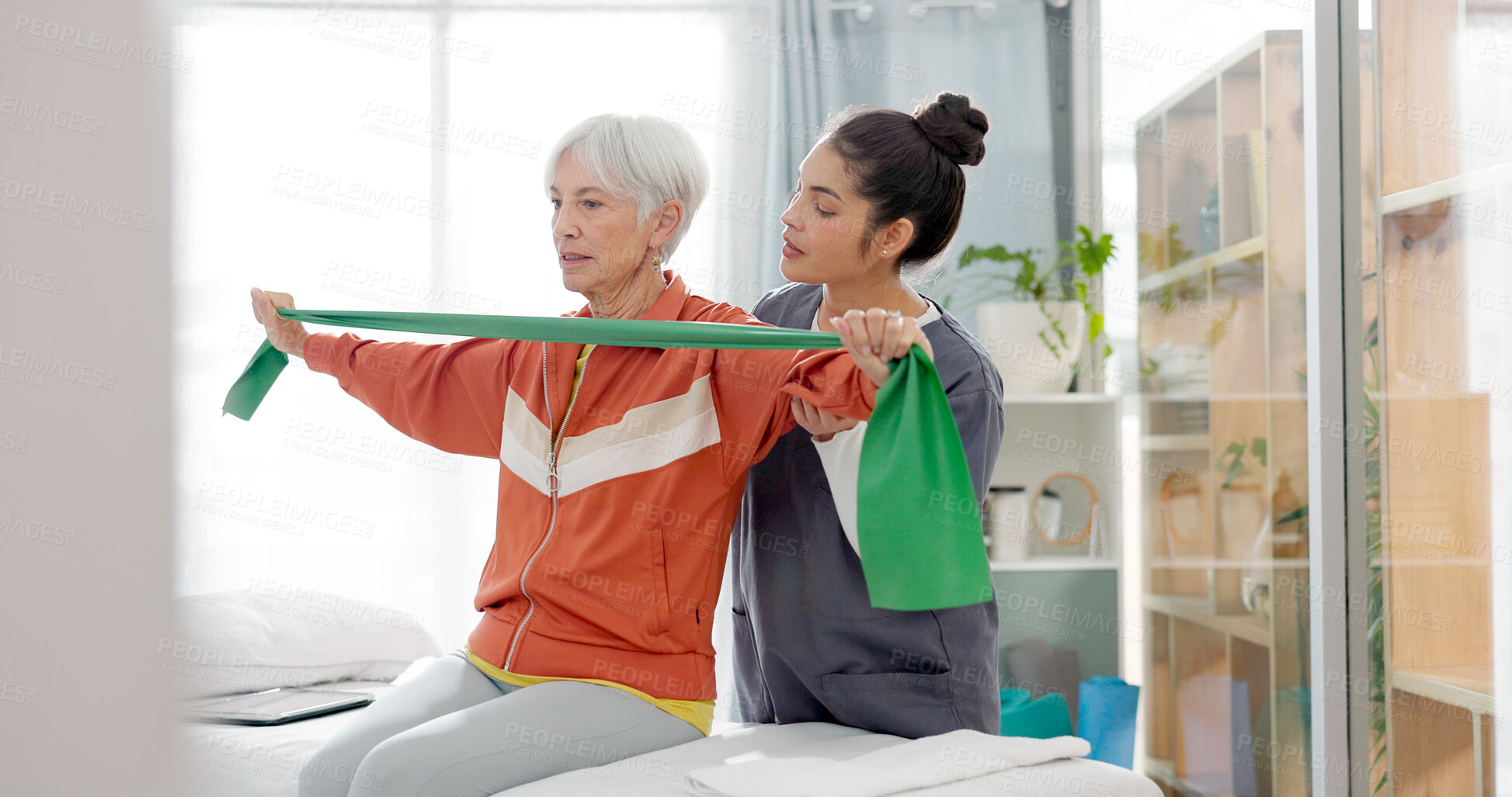 Buy stock photo Senior woman doing a exercise with a resistance band for physiotherapy with a nurse in clinic. Fitness, healthcare and elderly female patient doing arm workout with therapist in rehabilitation center