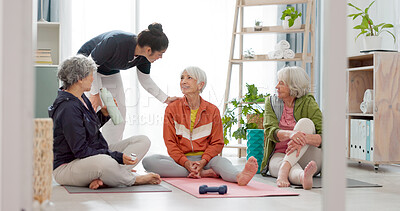 Senior woman, exercise group and personal trainer on floor, home and talk for training advice, workout or health. Elderly lady, team and fitness coaching with chat, drinking water and relax in house