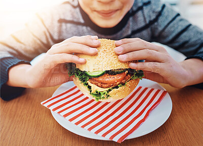 Buy stock photo Fast food, hands and boy eating burger in restaurant  for lunch, nutrition or childhood development. Hungry, sandwich and young kid by table for delicious meal, healthy vegetables or dinner in diner