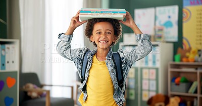 Child, face and book on head in school classroom for education learning in kindergarten, scholarship or happy. Kid, smile and knowledge academy for student creativity as reading, lesson or library