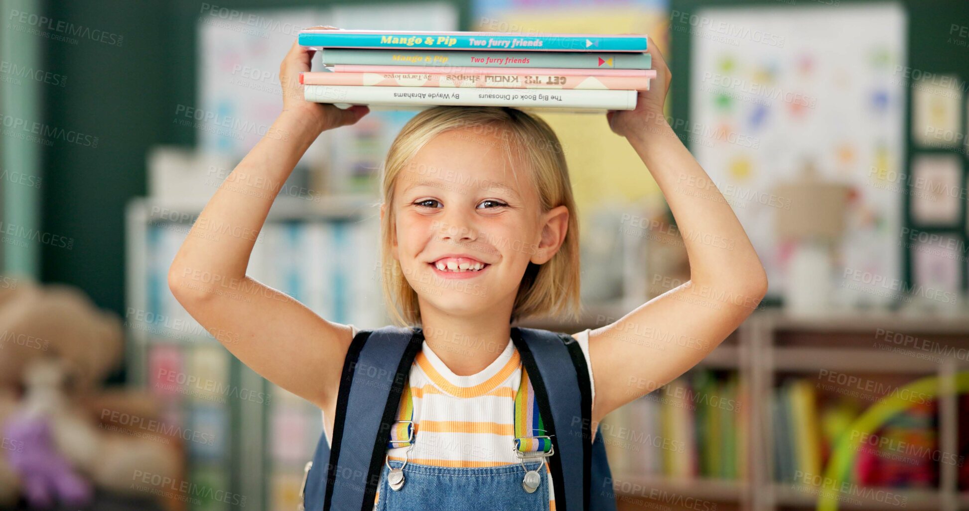 Buy stock photo Happy, young girl and books on her head in kindergarten school for child development, growth and learning. Smile, female person or student with novel for story time with education, study and reading