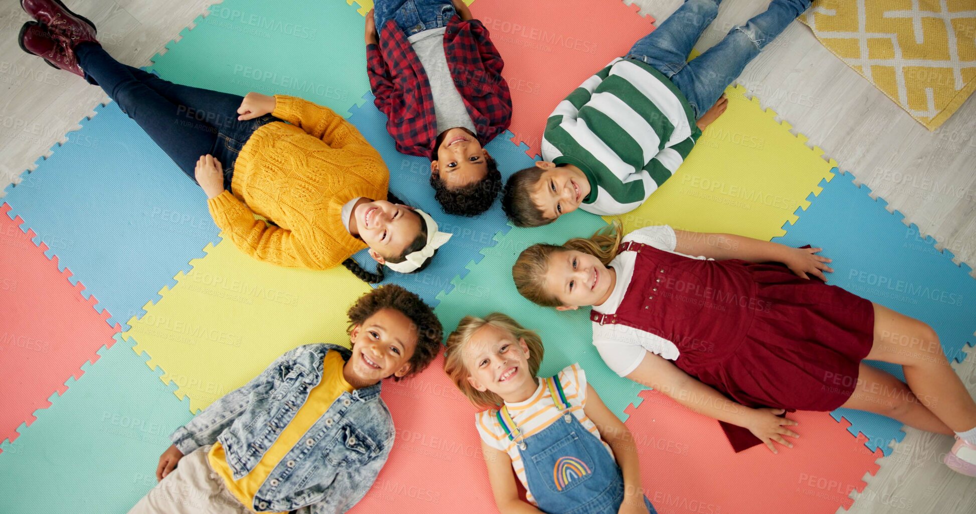 Buy stock photo Kids, lying down and circle in school with top view for relax, fun and classroom on colourful foam mat. Group, children and happy on floor for education, learning and knowledge with game for bonding