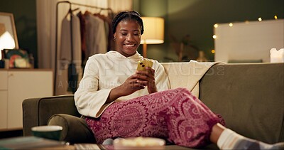 Black girl, happy and smartphone on sofa in home scrolling or online social media memes, videos and funny text. Woman, texting and mobile on couch to relax with entertainment, streaming and internet.