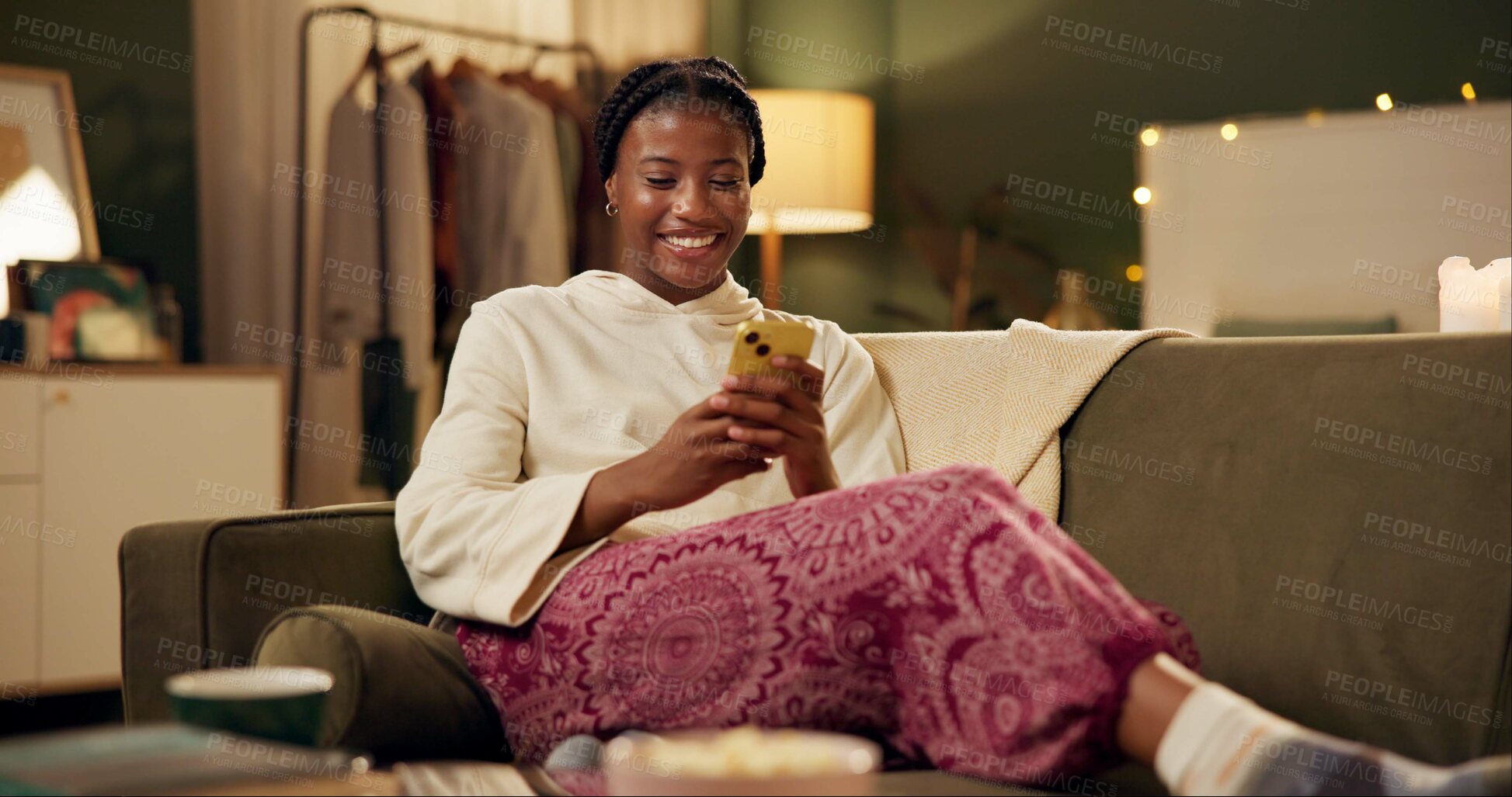 Buy stock photo Black girl, happy and smartphone on sofa in home scrolling or online social media memes, videos and funny text. Woman, texting and mobile on couch to relax with entertainment, streaming and internet.