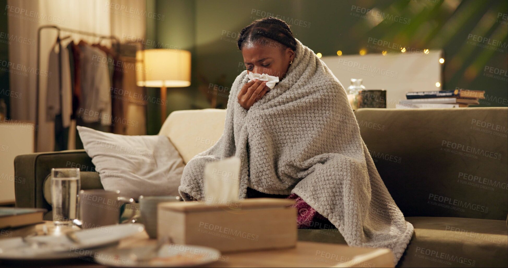 Buy stock photo Woman, cold and tissue with blanket on sofa for blowing nose, recovery or winter virus in living room. African person, infection or sick with fever, sinus and allergy on couch in home with healthcare