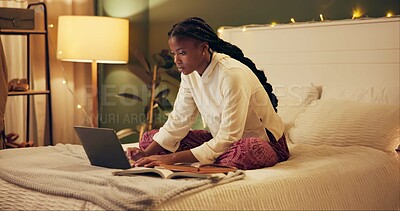 Buy stock photo Education, laptop and night with black woman in bedroom at home for distance learning or remote study. Computer, notebook and research with college or university person on bed of apartment in evening