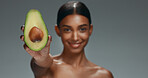 Beauty, skincare and happy woman in studio with avocado, natural cosmetics isolated on grey background. Makeup, healthy organic dermatology and skin care model with spa or salon fruit detox facial.