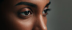 Eyes, face and skincare with a woman on a gray background in studio closeup for cosmetics. Beauty, vision and natural care with a young person looking confident with her skin or facial treatment