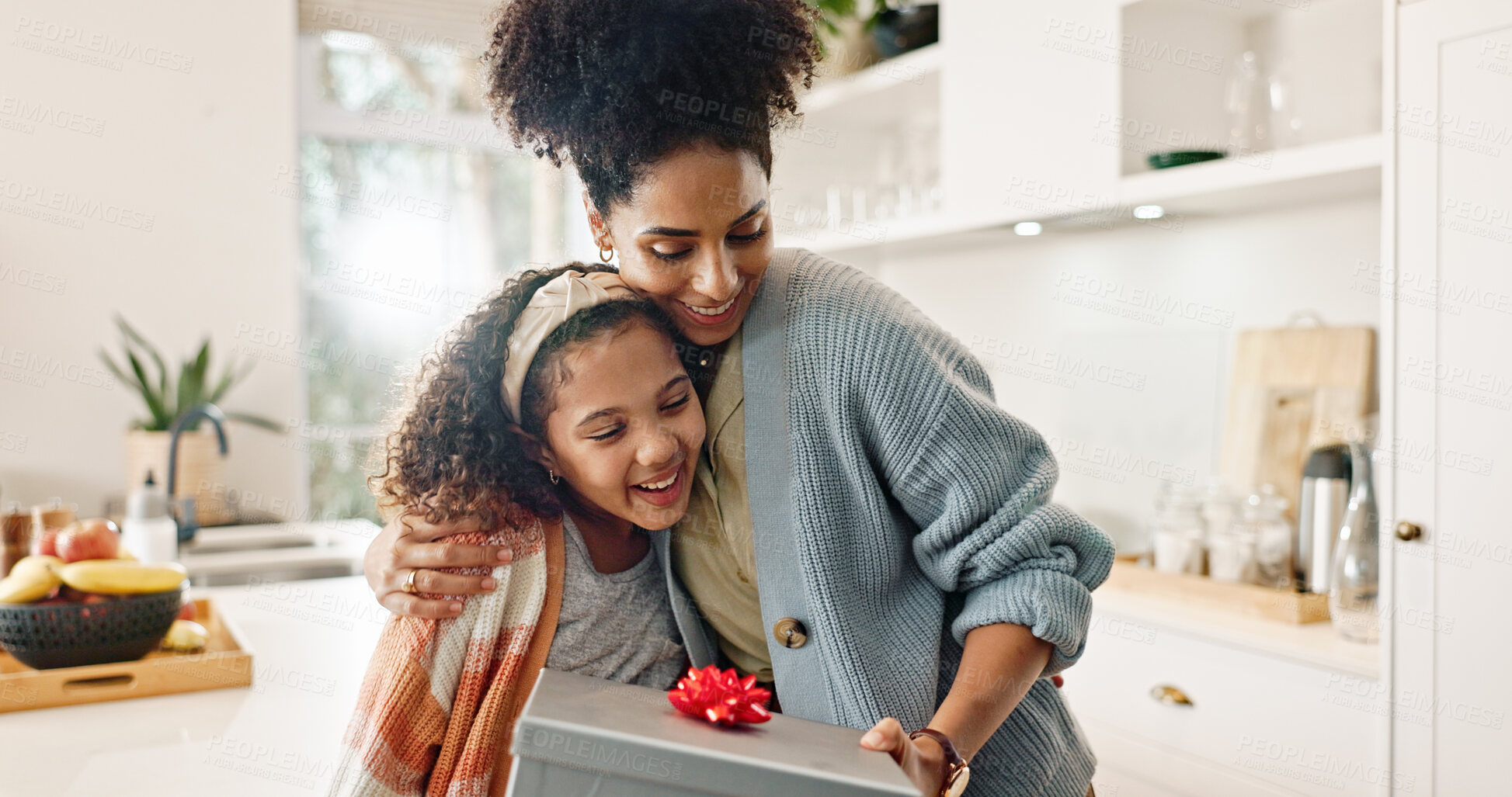 Buy stock photo Kitchen, mother and girl with gift, hug and smile for mothers day, love and care in family and house. Home, mom and daughter with embrace, happiness and cute in apartment, woman or child with present