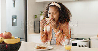 Child, sandwich and eating lunch in home kitchen or healthy nutrition with orange juice, student or breakfast. Girl, kid and morning hungry or bread snack in apartment for fiber meal, diet or food