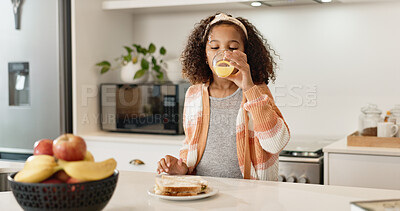 Buy stock photo Child, home and drinking orange juice or lunch meal or healthy sandwich, vitamin c or fiber. Girl, student and kitchen  counter or back to school nutrition in apartment for snack, hungry or wellness