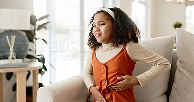 Buy stock photo Young girl, stomach ache or allergies on couch in home for health problem or digestion recovery on weekend. Child, pain or food poisoning in living room with cramps for belly discomfort and suffering