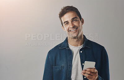 Buy stock photo Man, portrait and cellphone research in studio on grey background for digital app, online shopping or mockup space. Male person, face and smartphone with internet connection, texting or networking