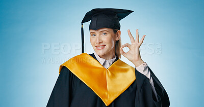Graduation, okay and woman with success in studio for education, learning or college achievement. Portrait of student with hands or emoji for yes, excellence and certified or good on blue background