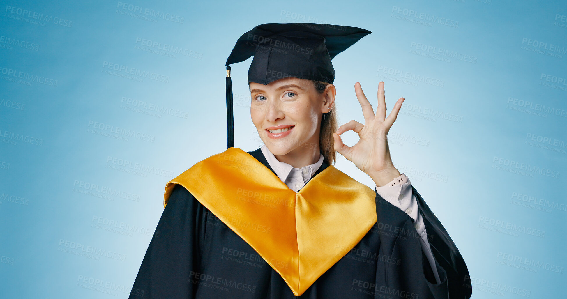 Buy stock photo Graduation, okay and woman with success in studio for education, learning or college achievement. Portrait of student with hands or emoji for yes, excellence and certified or good on blue background