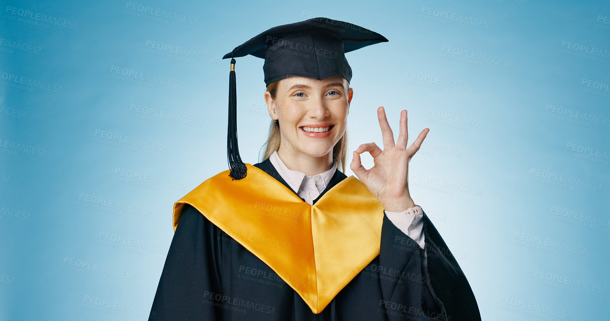 Buy stock photo Graduation, okay and student with success in studio for education, learning or college achievement. Portrait of woman with hands or emoji for yes, excellence and certified or good on blue background