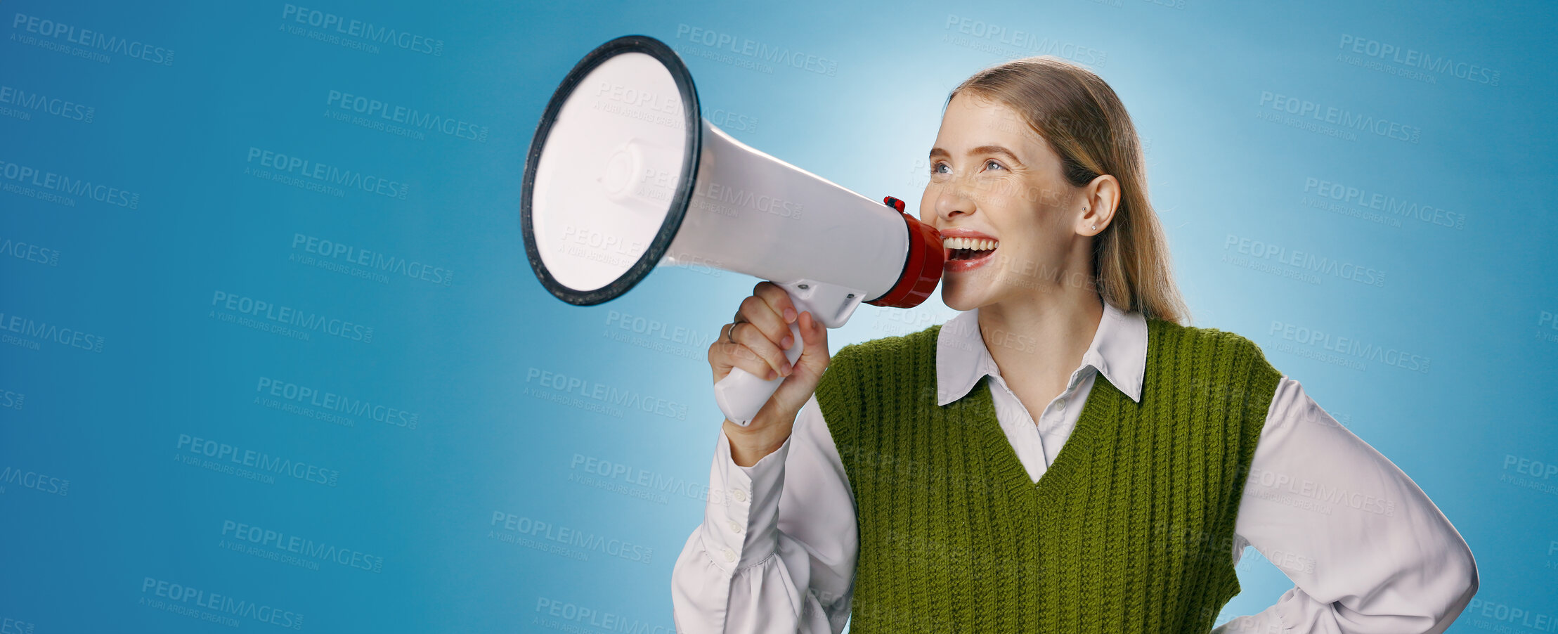 Buy stock photo Girl, megaphone and voice in studio for announcement, broadcast or join us with opportunity, news or mockup. Excited young person or gen z speaker in noise or attention on banner and blue background