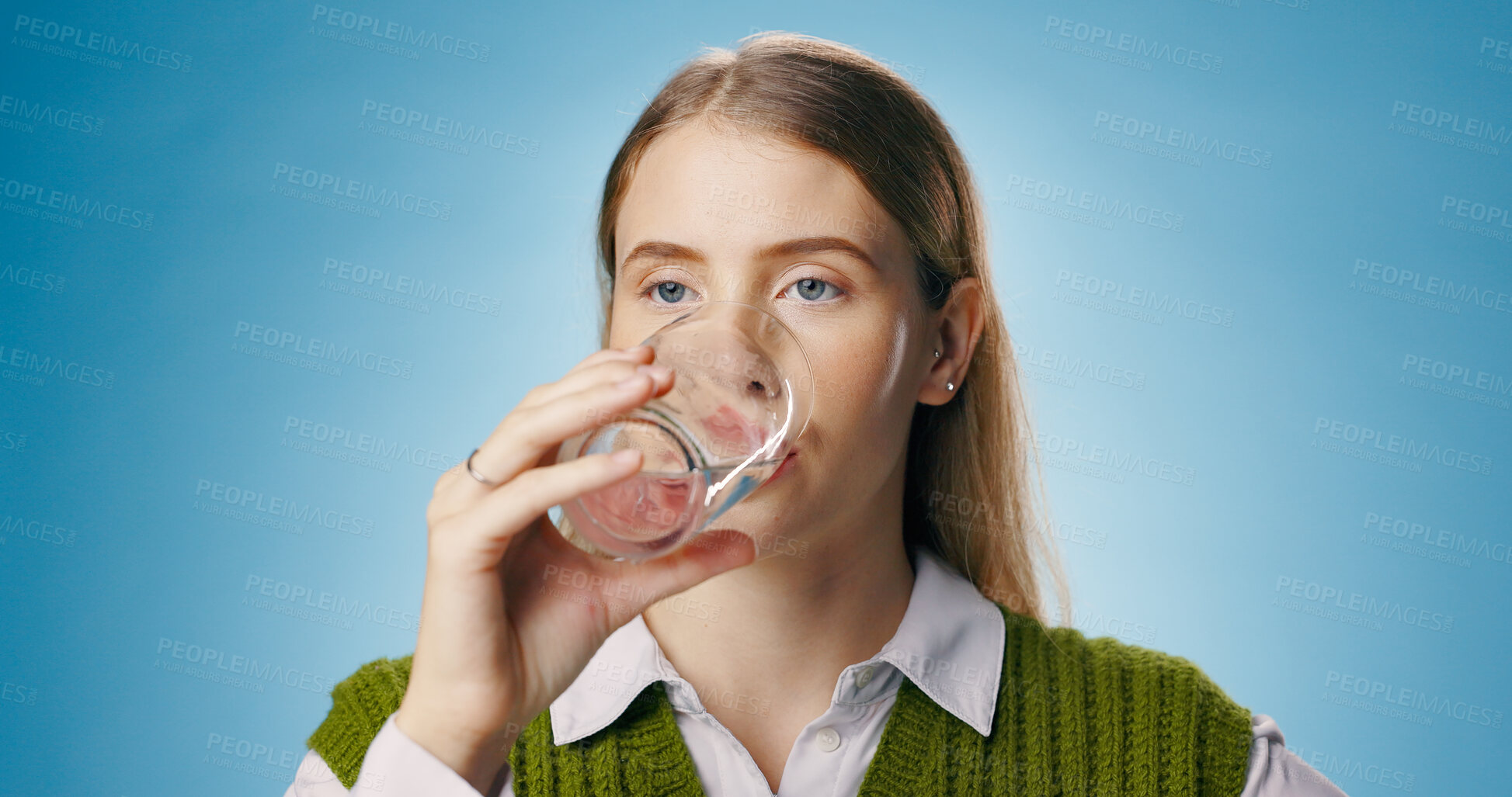 Buy stock photo Water, glass and woman for hydration in studio, drink and beverage for detox on blue background. Thirsty, liquid and h2o for gut health and clear skin, female person and nutrition   or wellness
