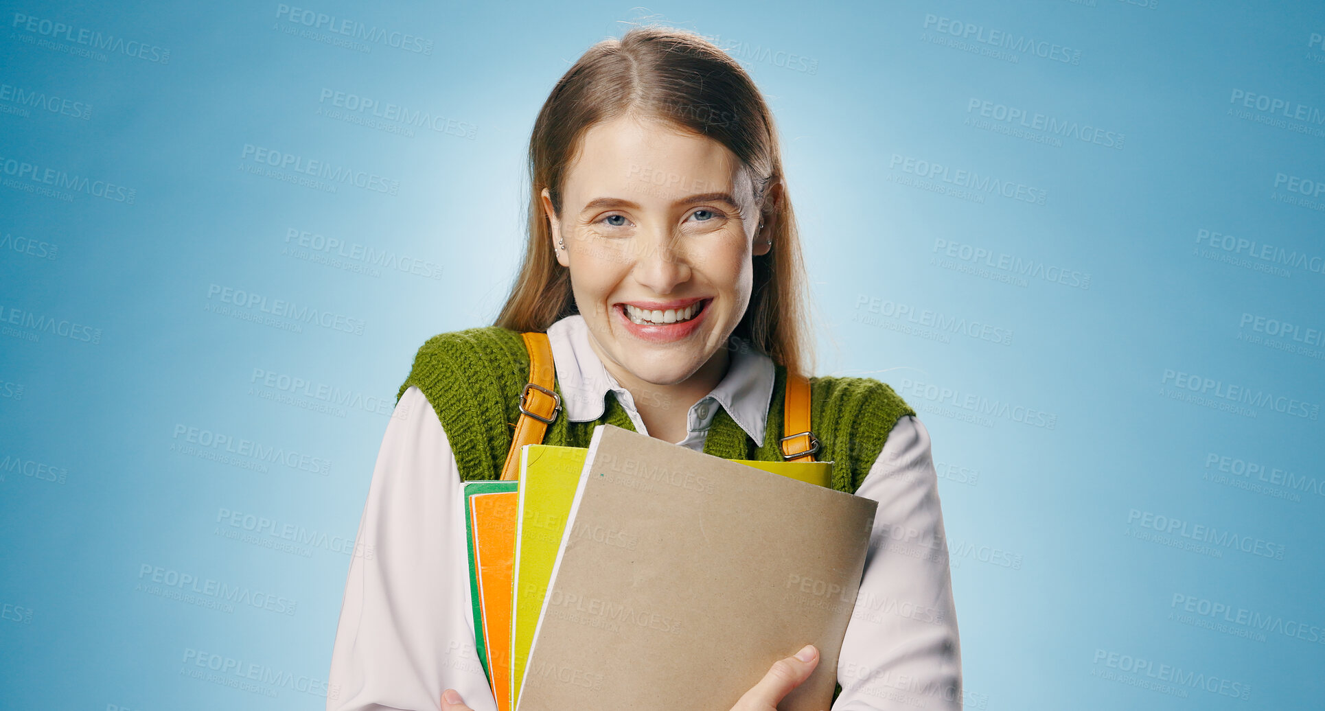 Buy stock photo Books, woman and portrait of student in studio with happy, smile and confidence for university. Learning, education and female person from Australia with study for college exam by blue background.