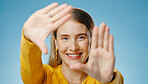 Woman, hands and frame with happy portrait or smile,  photographer perspective for social media post. Blue background, profile picture and cosmetic beauty, glow and confident for capture selfie