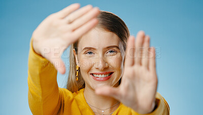 Buy stock photo Woman, hands and frame with happy portrait or smile,  photographer perspective for social media post. Blue background, profile picture and cosmetic beauty, glow and confident for capture selfie