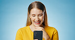 Woman, happy and reading with smartphone in studio, blog update and message notification on networking app. Social media, communication and smile for news or email, blue background and online survey