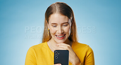 Buy stock photo Woman, happy and reading with smartphone in studio, blog update and message notification on networking app. Social media, communication and smile for news or email, blue background and online survey