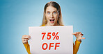 Shock, sale and portrait of woman with poster on blue background for news, announcement and advertising. Shopping, wow and happy person with sign for price discount, deal and bargain in studio