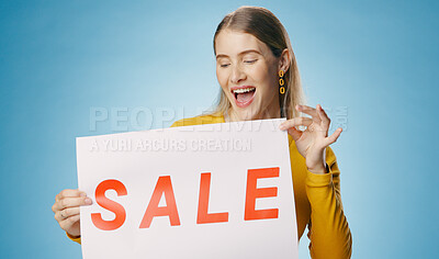 Woman, excited and sale poster in studio for shopping, retail and discount announcement of store or shop. Young person or seller with sign for news in fashion and wow or surprise on blue background