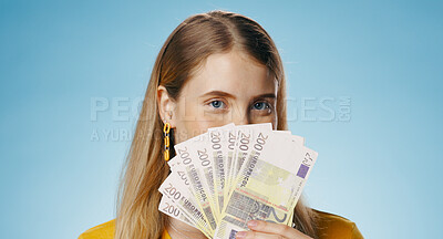 Cash, portrait and woman cover face in studio with money fan for finance, loan or savings on blue background. Portrait of winner or person hide with budget secret, lottery or gambling for investment