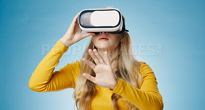 Buy stock photo VR, woman and hand in studio for metaverse, digital and video game on blue background. Technology, virtual and streaming for gamer person, hobby and internet for 3d augmented reality experience