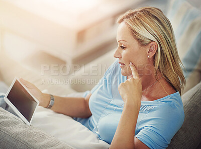 Buy stock photo Woman, tablet and reading on sofa in home with mock up space on screen with app, streaming or ebook in lounge. Person, digital touchscreen and relax on couch with movie, film or video subscription