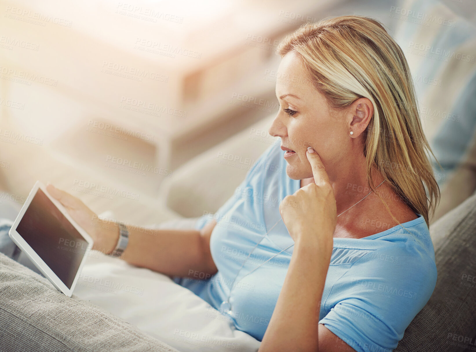 Buy stock photo Woman, tablet and reading on sofa in home with mock up space on screen with app, streaming or ebook in lounge. Person, digital touchscreen and relax on couch with movie, film or video subscription