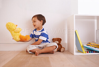 Buy stock photo Child, toy and play with teddy, smile and happiness for fun and joy at home or daycare. Boy, cute and positive with stuffed animal, laugh and childcare for growth and cheerful on wood floor in house