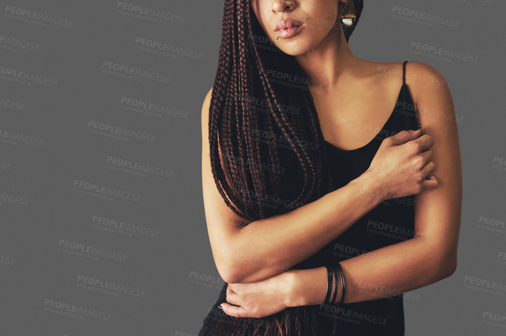 Buy stock photo Woman, arms and tattoo with dress in studio with edgy style, piercing and punk aesthetic by dark background. Girl, person and model with hands with braids by mock up space with skin art with fashion