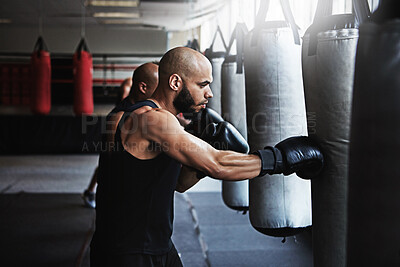 Buy stock photo Hit, punching bag and man in gym with boxing gloves for workout, challenge or competition training. Power, muscle and champion boxer in exercise with confidence, fitness and energy in MMA sports club