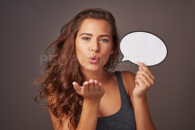 Buy stock photo Speech bubble, blowing kiss and portrait of woman in studio for news, flirting and feedback. Mockup space, social media and person with sign for information, announcement and emoji on dark background