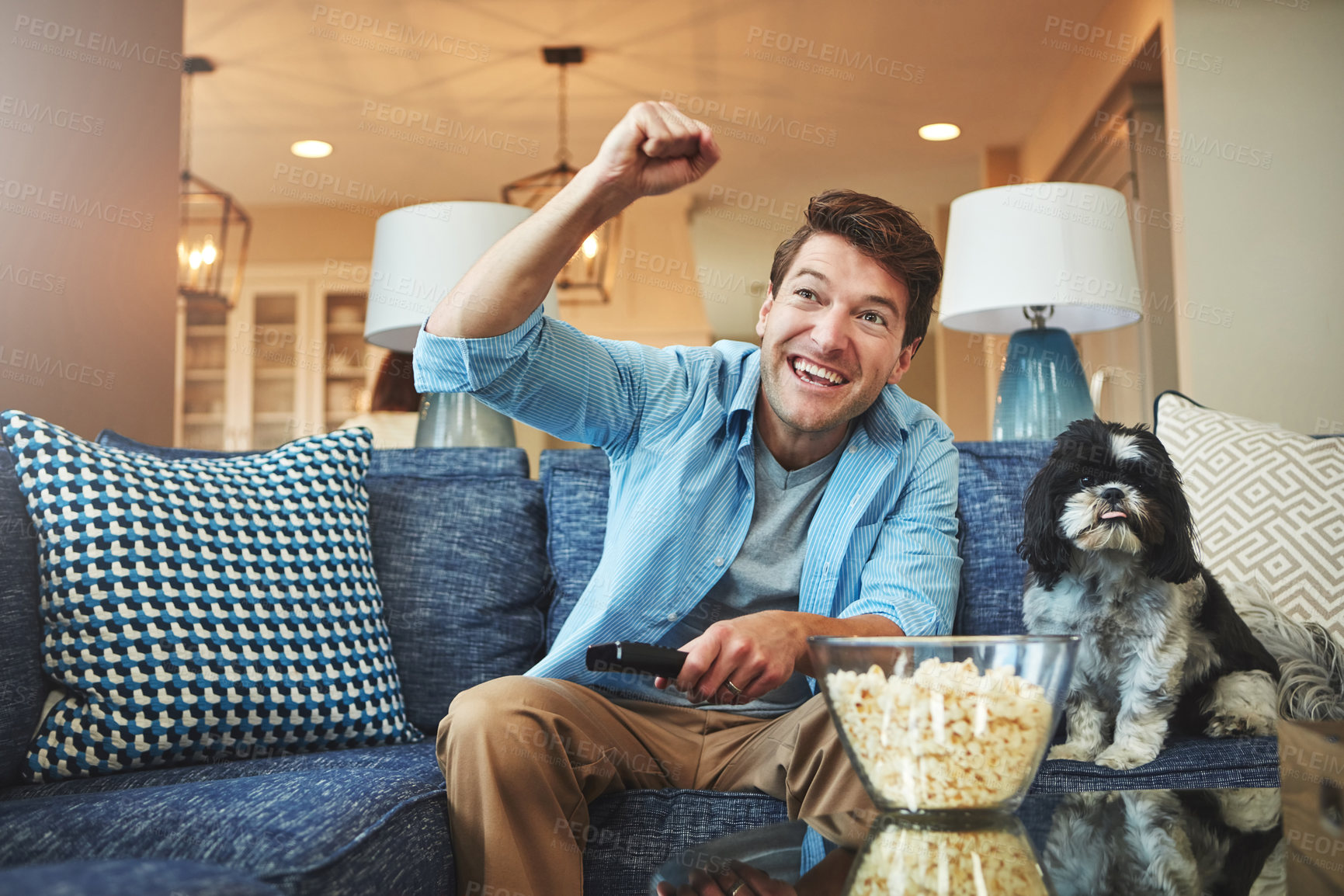 Buy stock photo Happy, man and dog with tv remote or popcorn in home on sofa for watching sports game, challenge and fun. Living room, couch and excited or smile with fist for celebration, win and entertainment