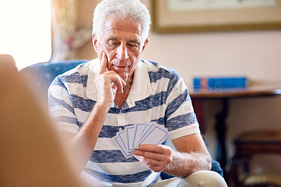 Buy stock photo Elderly man, relax and thinking with playing cards at home for strategy, problem solving and activity. Games, senior person and poker in retirement with idea for contest, challenge and solution