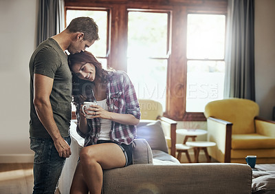 Buy stock photo Couple, coffee and home with love, kiss and smile in marriage, relax and peace in break and morning. House, man and woman on sofa, together and rest in living room, bonding and happy for relationship