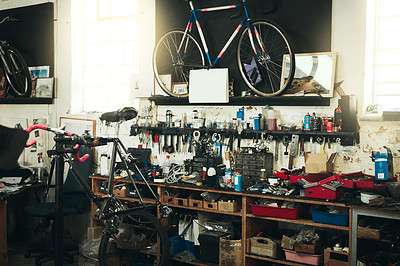 Buy stock photo Bicycle, workshop and tools with equipment for mechanical repair, fix or maintenance at indoor garage. Empty place with workbench with bike, gears or parts for cycling or engineering at repair shop