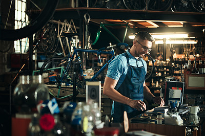 Buy stock photo Happy man, bicycle mechanic and workbench with tools in small business for fix, repair or maintenance. Young male person, cycle engineer or bike technician with smile for job or equipment at workshop