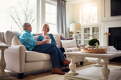 Buy stock photo Senior couple, coffee and talk on couch in conversation, relax or happy memory in home living room. Old man, elderly woman and chat for bonding with care, love or story in retirement on sofa in house