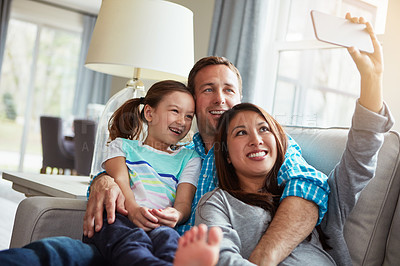 Buy stock photo Interracial parents, girl and selfie on sofa with smile, hug and relax with care, app or memory in home. Happy father, mother and daughter with embrace, social media or love on couch in family house