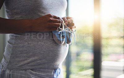 Buy stock photo Hands, baby shoes and pregnant woman in home, stomach and motherhood in apartment. Closeup, person and girl with belly, sneakers or pregnancy with wellness, hope for future or expectation in house