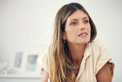 Buy stock photo Cropped shot of an attractive woman looking thoughtful at home